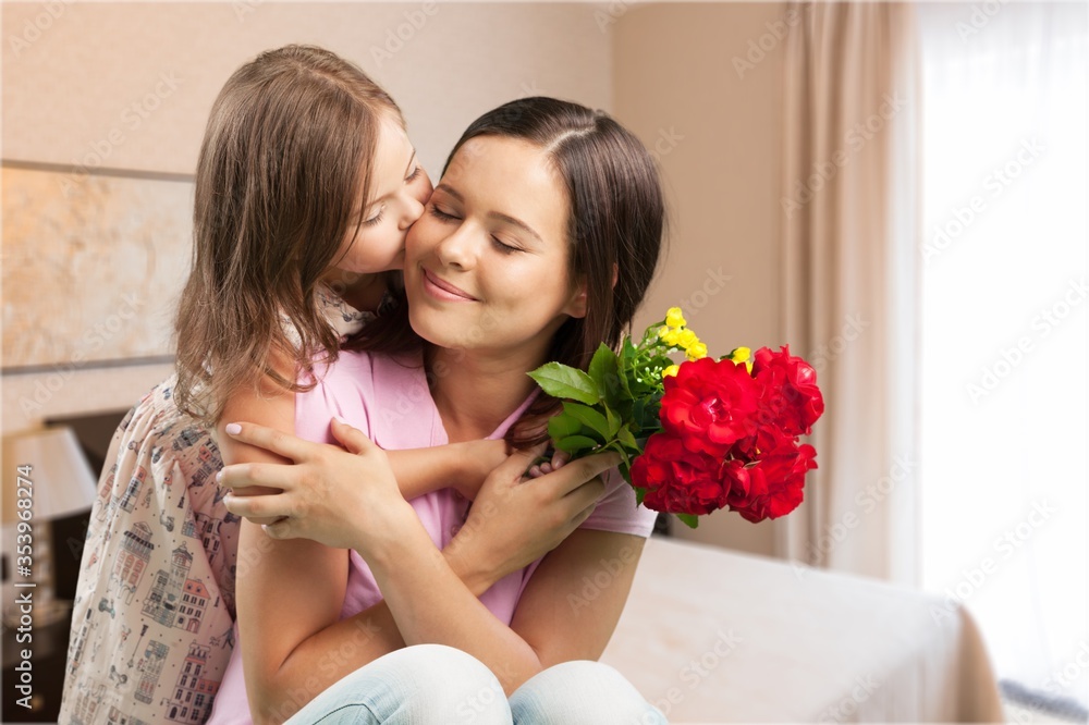 Happy beautiful mother and daughter hugging with a bouquet Happy beautiful mother and daughter hugging with a bouquet