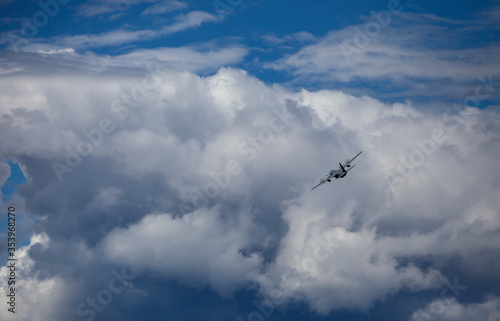 Transport plane banking left and cumulus clouds