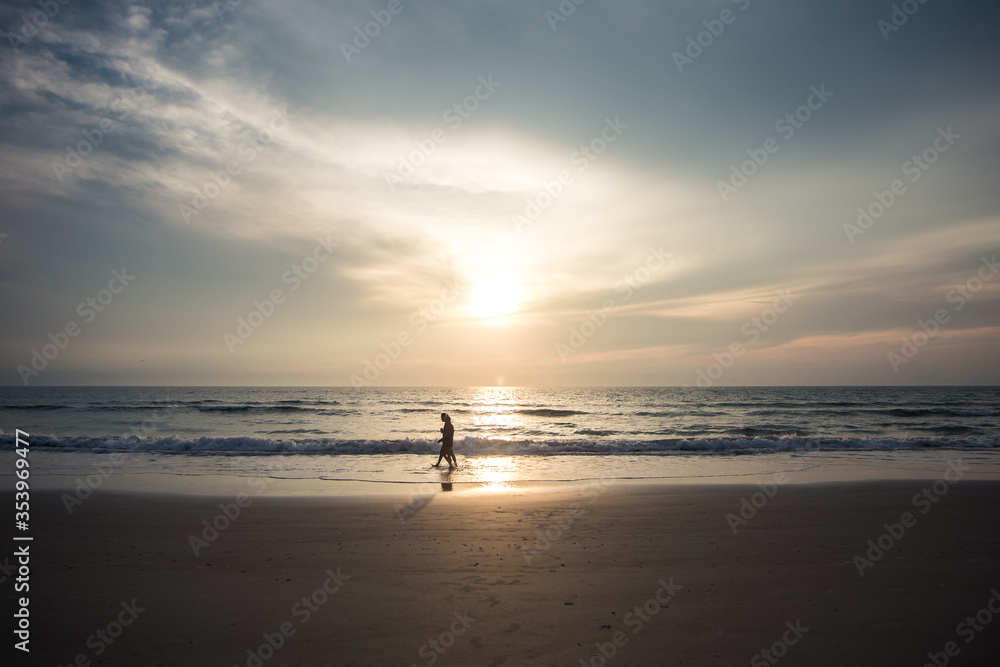 Couple on a walk on the beach at sunrise