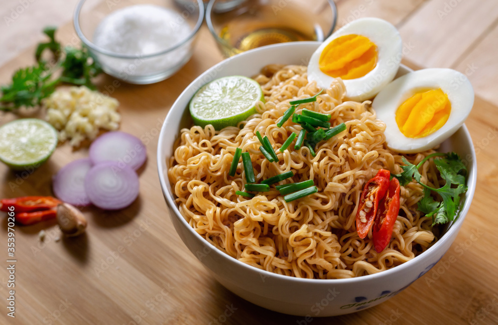 Instant noodles in bowl on wood background top view, Asian meal on a table.
