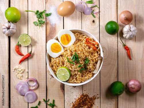 Instant noodles in bowl on wood background top view, Asian meal on a table.