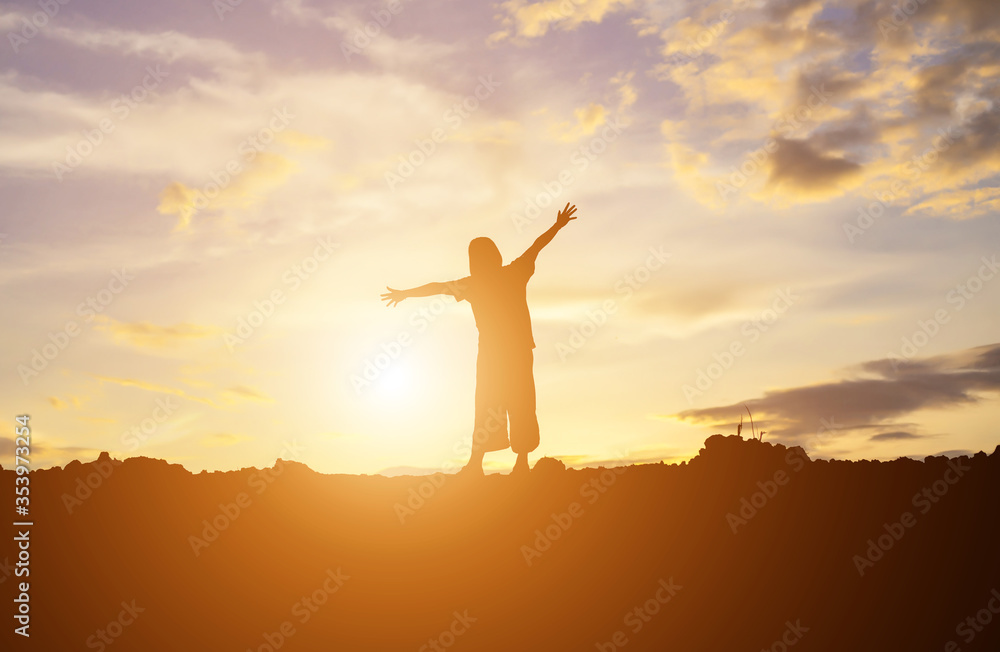 Silhouette of woman praying over beautiful sky background