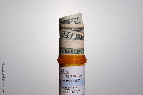 Prescription pill bottle filled with US currency/cash.