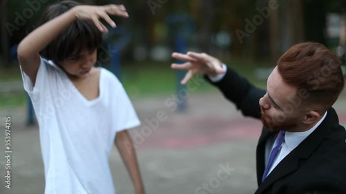 Father and child doing fist bump. Interracial parent and son offsping doing fist bump handshake bonding together photo