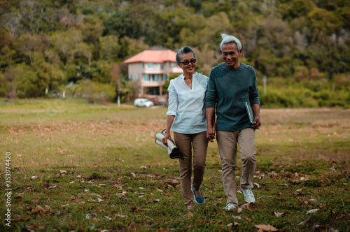 Romantic senior couple. walking resting on green grass in the park. Love is everything,blurred background and image no focus..Retirement age concept and love, copy space for text