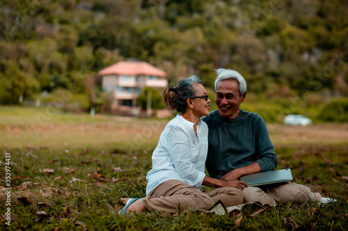 Romantic senior couple. sitting resting on green grass in the park. Love is everything,blurred background and image no focus..Retirement age concept and love, copy space for text