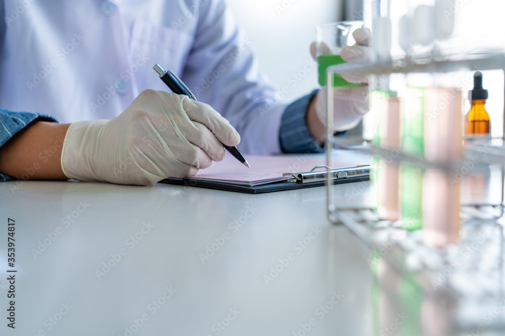Scientist wear lab coat and protective wear are working with research or doing investigations with test tubes in experiment, Laboratory and development concept Scientist wear lab coat and protective wear are working with research or doing investigations with test tubes in experiment, Laboratory and development concept