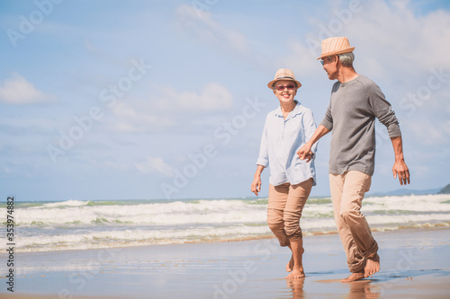 Happy retired couple holding hands and walking together each other talking happily. Love is everything.. Retirement age concept and love, copy space for text