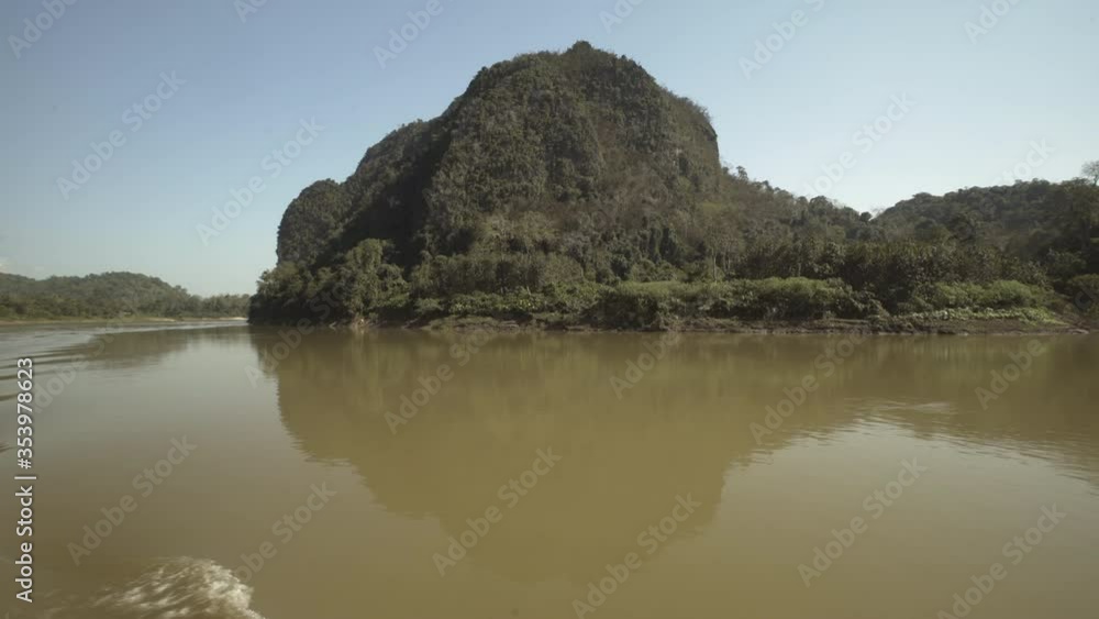 Panning shot of trees covered mountains by river against clear sky - Vientiane, Laos Panning shot of trees covered mountains by river against clear sky - Vientiane, Laos