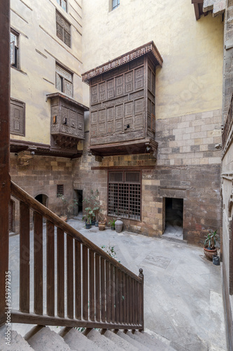 Facade of ottoman era historic house of Zeinab Khatoun with wooden oriel windows - Mashrabiya - and staircase with wooden balustrade located at Azhar district, Medieval Cairo, Egypt photo