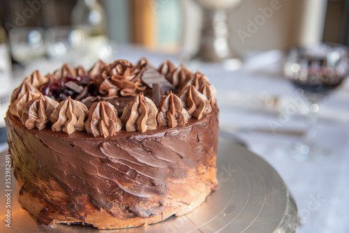 Close up on beautifully decorated and presented chocolate fudge cake with stunning topping. 