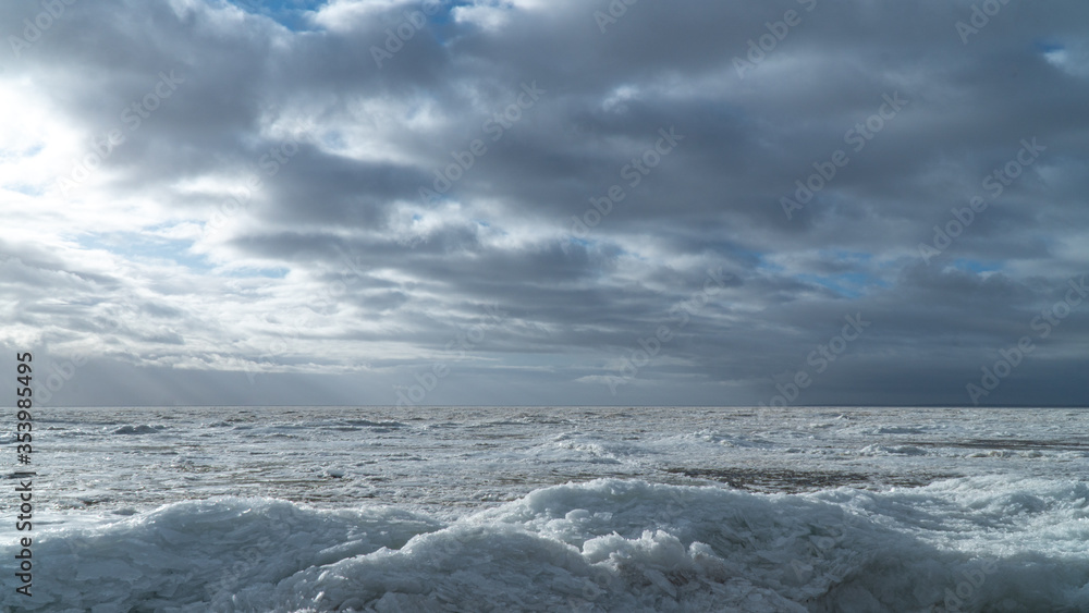 Scenery of a beautiful cloudy sky over an ice-covered pond Scenery of a beautiful cloudy sky over an ice-covered pond