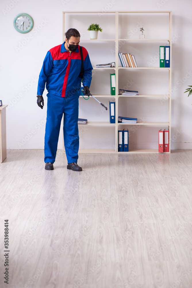 Young male contractor disinfecting office Young male contractor disinfecting office