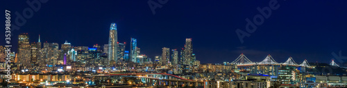 San Francisco skyline night panorama with city lights, the Bay Bridge and light trails on the highway
