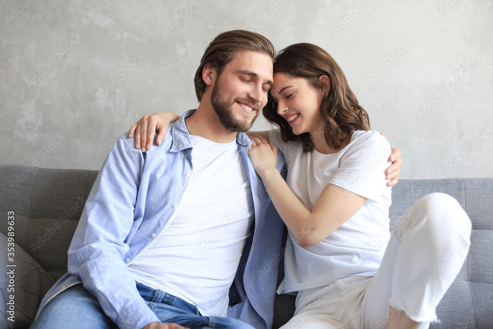Young loving couple relaxing on sofa together. Woman and man embrace enjoy company of each other sitting on couch holding hands having romantic date. Young loving couple relaxing on sofa together. Woman and man embrace enjoy company of each other sitting on couch holding hands having romantic date.