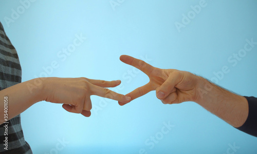 Hands of couple playing rock paper scissors © zakharovs