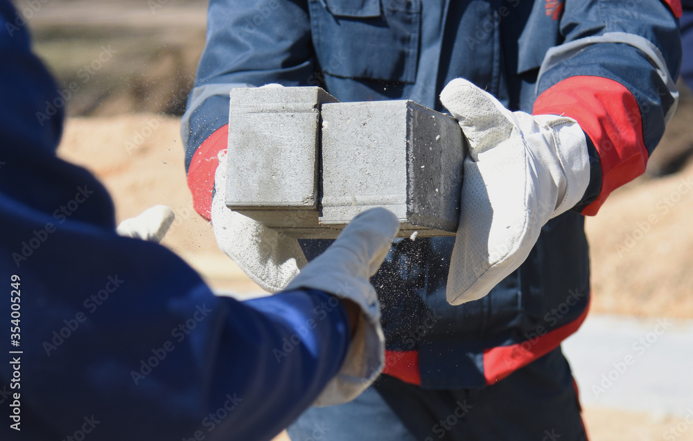Concrete blocks in the hands of builders, close-up.