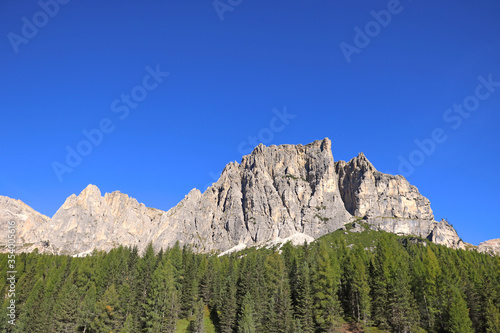 Beautiful Dolomites in Italy. Clear day with blue sky. Mountains are illuminated by the rays of the sun. Clean fresh air. Selective focus.
