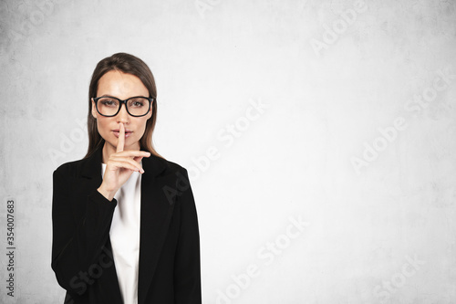 Businesswoman in glasses making hush sign, mock up