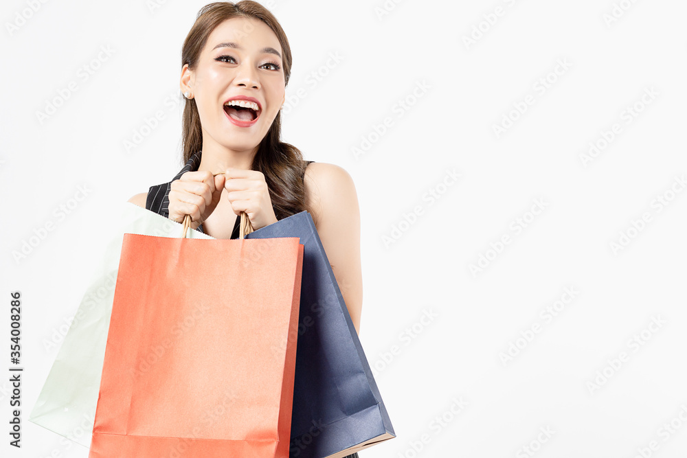 Portrait of young beautiful asian girl wearing black dress holding shopping bags and smile isolated over white background. Online shopping and black friday concept. Portrait of young beautiful asian girl wearing black dress holding shopping bags and smile isolated over white background. Online shopping and black friday concept.