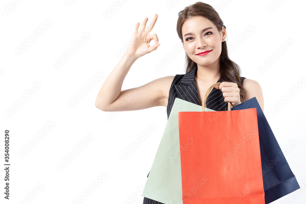 Portrait of young beautiful asian girl wearing black dress holding shopping bags and smile isolated over white background. Online shopping and black friday concept. Portrait of young beautiful asian girl wearing black dress holding shopping bags and smile isolated over white background. Online shopping and black friday concept.