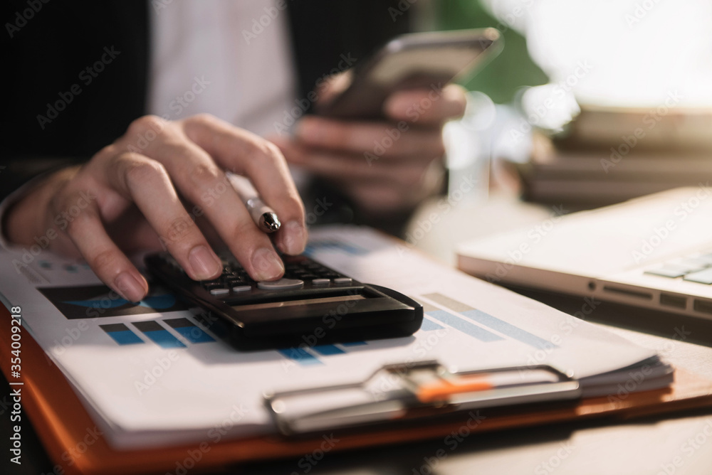 Hand businessman doing finances and calculate on desk about cost at home office. Hand businessman doing finances and calculate on desk about cost at home office.