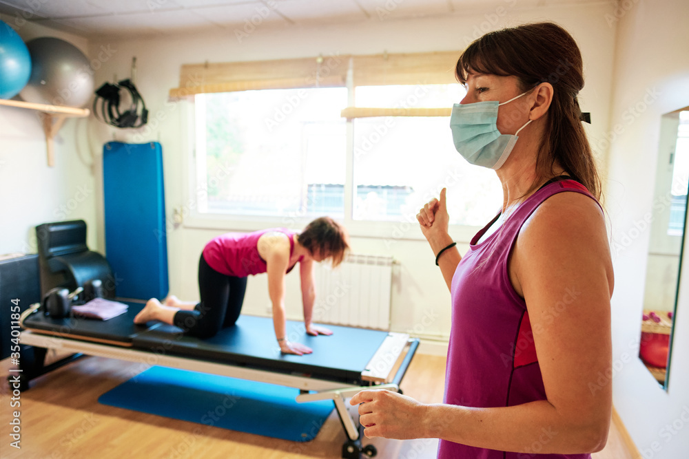 group of mature women doing excercise, Pilates and Yoga with social distancing and face mask group of mature women doing excercise, Pilates and Yoga with social distancing and face mask