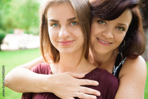 Cute young daughter embracing her mother with love.