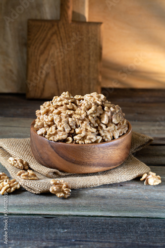 Walnuts in round bowl on wooden rustic background 