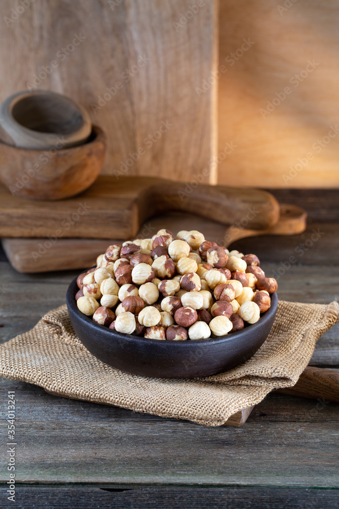 Hazelnuts in brown bowl on rustic wooden background. Hazelnuts in brown bowl on rustic wooden background.