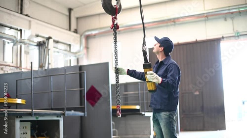 Worker operating a crane in an industrial plant