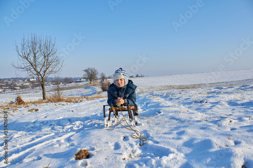 boy in winter on a sled,in winter on a sunny day the boy lies on a sled