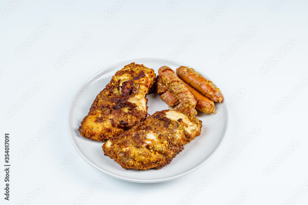 Burnt Grill Fried Chicken Breast Fillets with Sausages on White Plae Isolated. Burnt Grill Fried Chicken Breast Fillets with Sausages on White Plae Isolated.