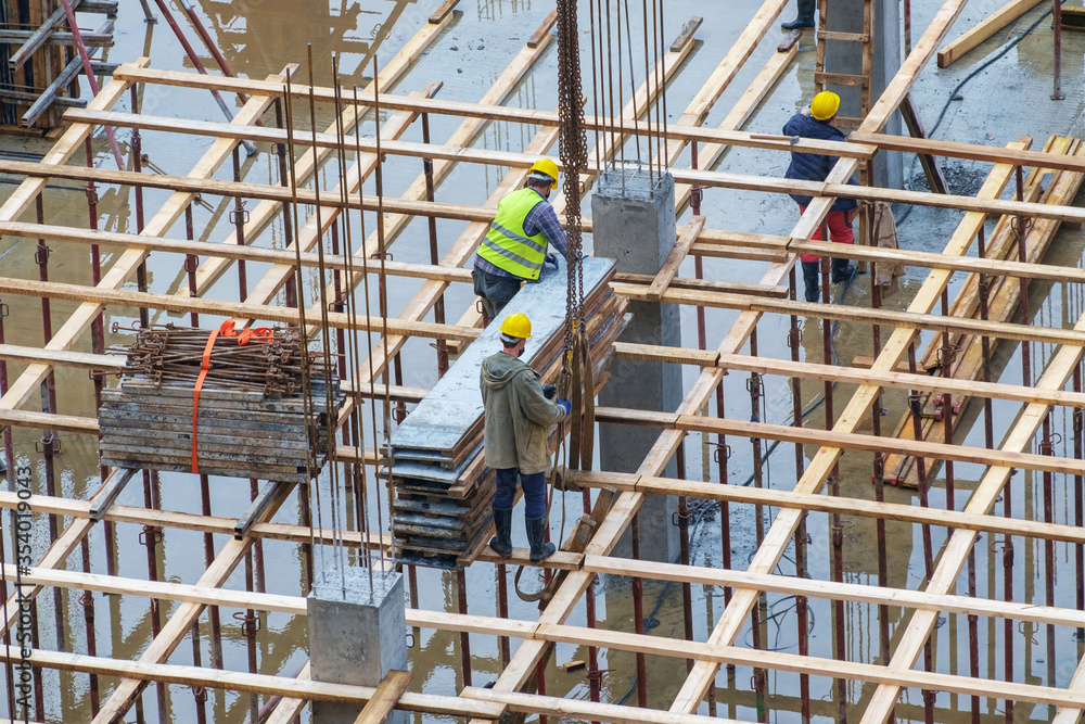 Construction workers working at rainy day on a construction site