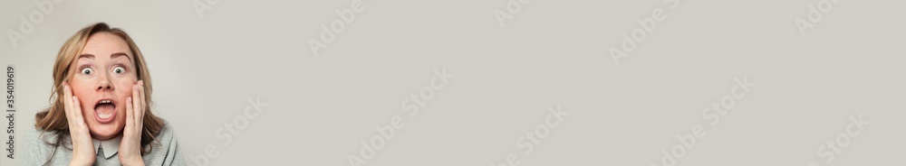 Surprised woman with opened mouth on white banner background with copy space Surprised woman with opened mouth on white banner background with copy space
