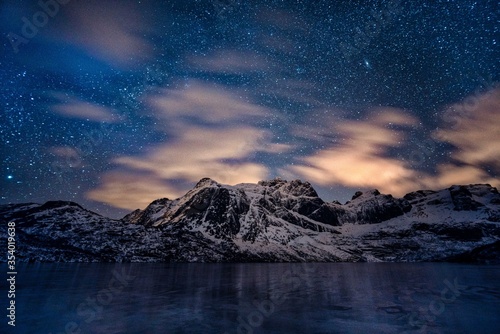 A soothing shot of starlight over snowy mountain ranges at Storvatnet lake, Norway