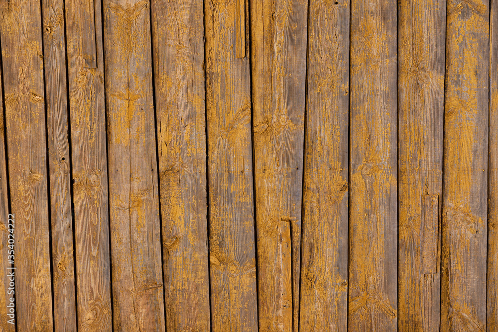 Texture of a yellow fence made of wooden boards