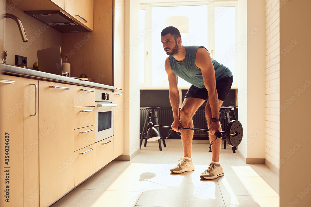 Handsome young man doing exercise with floor lamp Handsome young man doing exercise with floor lamp