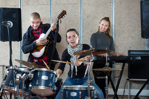Rehearsal of music group with female drummer