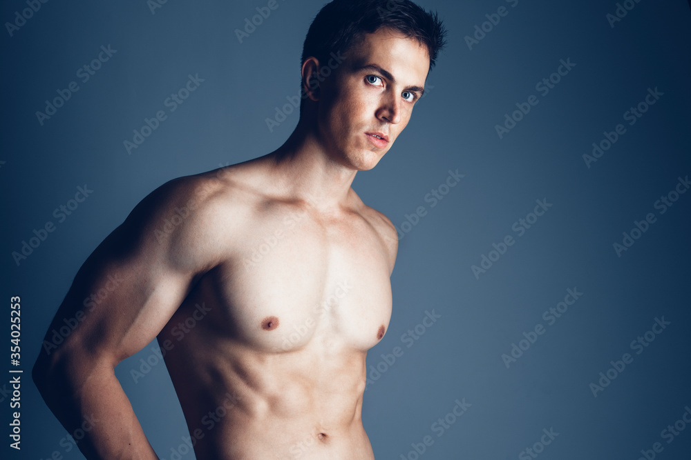 Male beauty concept. Portrait of a muscle handsome young man posing over blue background. Close up. Studio shot Male beauty concept. Portrait of a muscle handsome young man posing over blue background. Close up. Studio shot