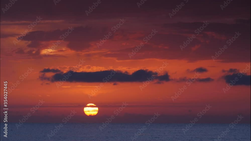 Seascape at early morning, sun rising over sea water. Burning orange sky. Nature landscape in Spain. Time laspe Seascape at early morning, sun rising over sea water. Burning orange sky. Nature landscape in Spain. Time laspe