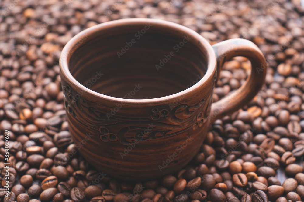 Brown ceramic cup with painted patterns. Coffee cup on the table. Brown ceramic cup with painted patterns. Coffee cup on the table.