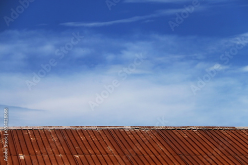 Galvanized roof old and rusty In the blue sky.