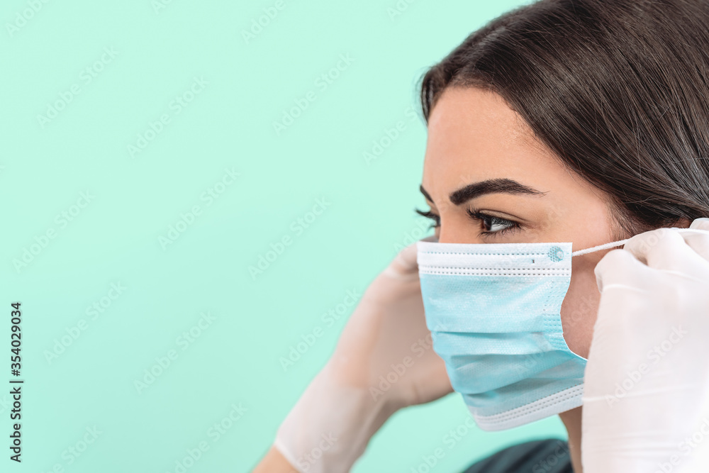 Young woman doctor portrait wearing surgical face mask and gloves - People working for preventing and stop corona virus spreading - Healthcare medicine and coronavirus impact concept Young woman doctor portrait wearing surgical face mask and gloves - People working for preventing and stop corona virus spreading - Healthcare medicine and coronavirus impact concept