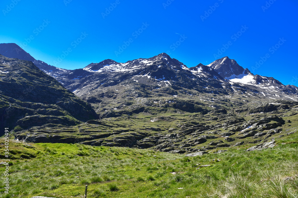 Summer mountain landscape with blue sky and snow.