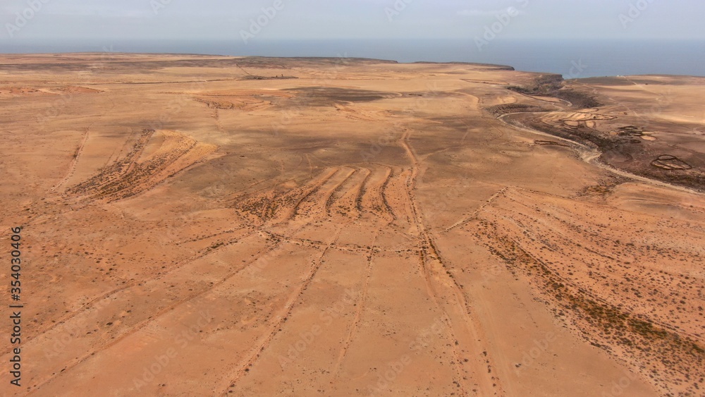 Naklejka premium Strolling allong desert trails where the horizon meets the sea and mountains