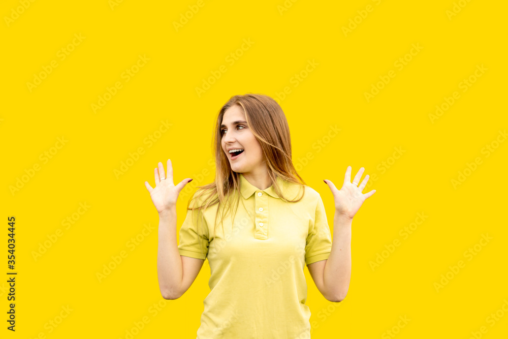 Young girl delighted with something. Dressed in a yellow T-shirt. Isolated on yellow background. Young girl delighted with something. Dressed in a yellow T-shirt. Isolated on yellow background.