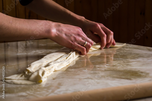 Woman, female hands preparing Balkan traditional food, cheese pie, close up