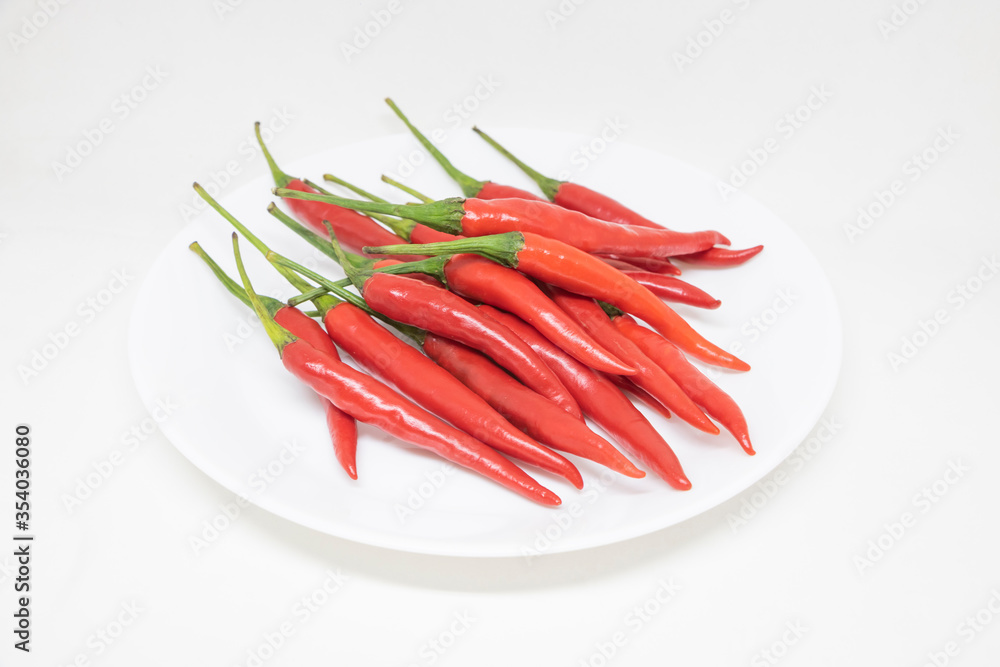 Red peppers on a white plate On a white background Red peppers on a white plate On a white background