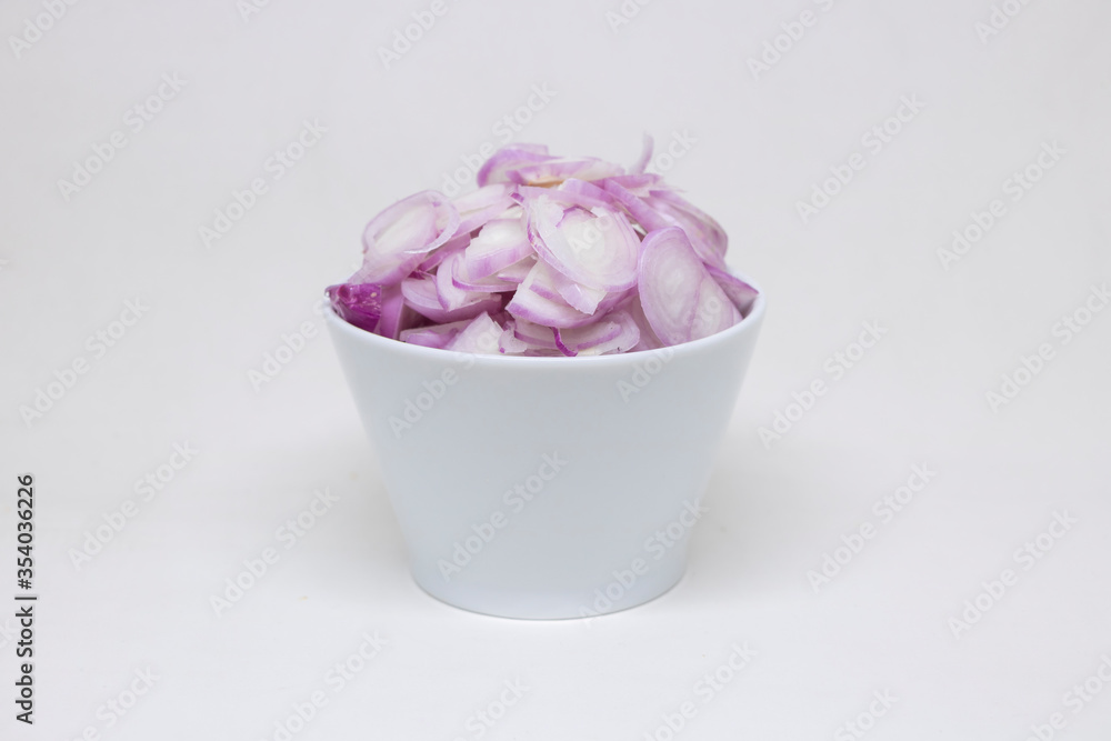 Sliced onions in a white cup on a white background Sliced onions in a white cup on a white background